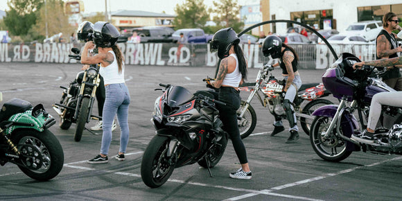 Della Crew stunt team: image of team members on motorcycle at a parking lot