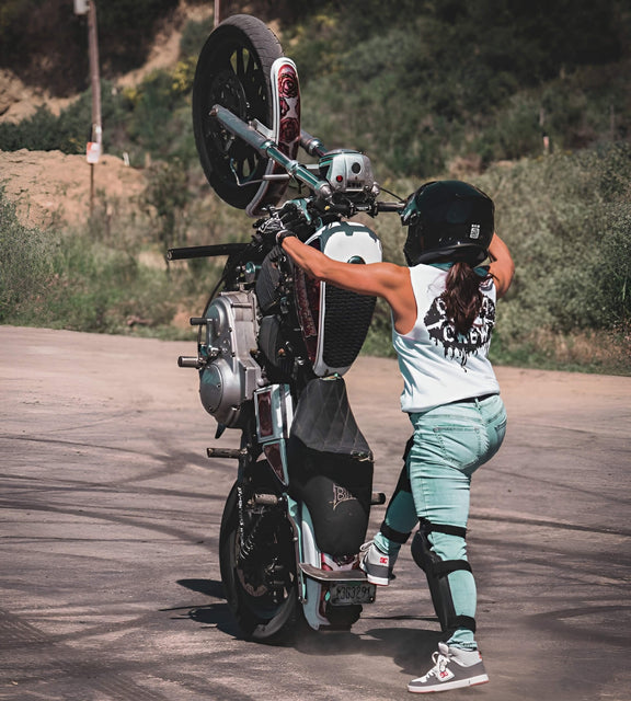 Image of stunt rider Ang on a white motorcycle doing wheelie