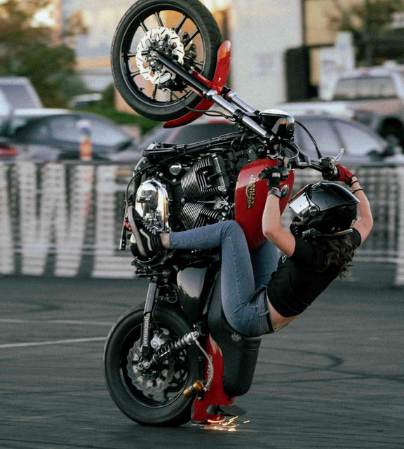 Image of stunt rider Darika on a red motorcycle doing wheelie
